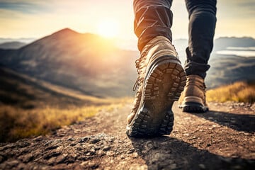 Un homme marche en montagne avec une paire de chaussure de randonnée. 